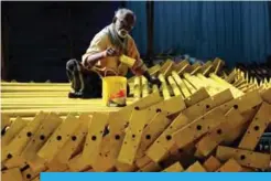  ??  ?? CHENNAI: An Indian laborer paints iron rods at an under-constructi­on site yesterday. — AFP