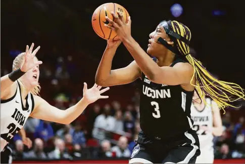  ?? Craig Mitchelldy­er / Associated Press ?? UConn’s Aaliyah Edwards, right, shoots over Iowa forward Monika Czinano during the first half on Sunday.