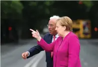  ?? Associated Press ?? ■ German Chancellor Angela Merkel, right, walks with Portuguese Prime Minister Antonio Costa before their meeting Thursday at the Foz palace in Lisbon. Merkel is in Portugal for a 24-hour official visit during which she will discuss the European...
