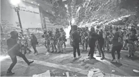  ?? JOSE SANCHEZ/AP ?? Officers advance on demonstrat­ors during a Black Lives Matter protest at the Mark O. Hatfield United States Courthouse in Portland, Ore.