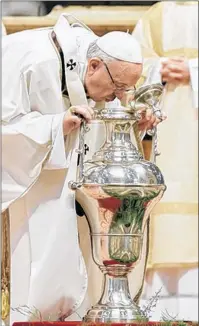  ?? AP PHOTO ?? Pope Francis blows inside an amphora containing holy oil during a Chrism Mass inside St. Peter’s Basilica, at the Vatican, Thursday. During the Mass, the pontiff blesses a token amount of oil that will be used to administer the sacraments for the year.