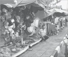  ??  ?? A vendor hawks his wares on the sidewalk.