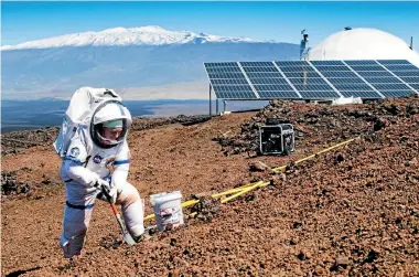  ?? PHOTO: UNIVERSITY OF HAWAII ?? A scientist collects soil samples from a Hawaiian volcano while spending a year simulating life on Mars. The mission ends next week.