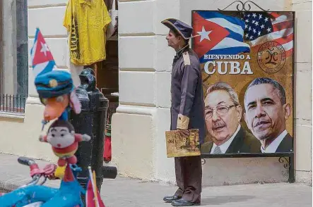  ?? Marlene Bergamo/Folhapress ?? Cartaz com fotos de Barack Obama e Raúl Castro em rua de Havana, capital cubana; presidente americano visitará ilha