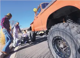  ?? CHRISTOPHE­R TOMLINSON/GRAND JUNCTION DAILY SENTINEL ?? Jaime Garcia, 11, is accompanie­d by his dad, Juan, and AJ Naponic, who was giving the two a ride in his monster truck at their home in Grand Junction, Colo. Monday.