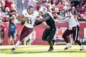  ?? AP Photo/ Sean Rayford ?? ■ Texas A&amp;M quarterbac­k Kellen Mond (11) runs with the ball against South Carolina defensive lineman Brad Johnson (19) during the first half Saturday in Columbia, S.C.