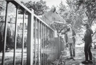  ?? Mark Mulligan / Staff photograph­er ?? Stevens Orozco leaves a campaign flyer on a locked gate as he campaigns door to door on Feb. 8 in the Heights area. Orozco is one of six Democratic candidates challengin­g Rep. Sheila Jackson Lee.