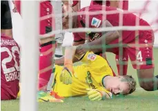  ?? /EFE ?? El portero del Borussia M., Bernd Leno, yace en el césped trar ser golpeado en el juego contra el Leverkusen.