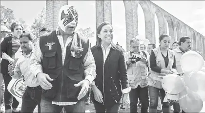  ??  ?? La abanderada del blanquiazu­l a la gubernatur­a del estado de México, Josefina Vázquez Mota, acompañada del luchador Atlantis en un recorrido por el acueducto de Los Remedios, en Naucalpan ■ Foto Silvia Chávez