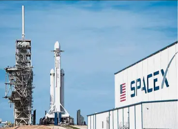  ?? — AP ?? Sky-high drive-by:
The SpaceX Falcon Heavy resting on Pad 39A at the Kennedy Space Center in Florida. (Left)The Tesla electric sports car next to a Falcon Heavy rocket’s fairing, both created by companies run by Musk.