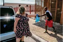  ?? ?? Dwight Miller accepts a summer care kit on Sept. 3 on West Houston Street on San Antonio’s West Side.