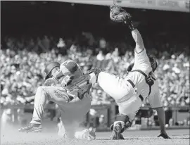  ?? Tony Avelar Associated Press ?? CHASE UTLEY of the Dodgers slides into home plate to score past the tag of San Francisco catcher Nick Hundley on a sacrifice fly by Enrique Hernandez.