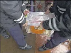  ?? ROSSIYA ONE TV CHANNEL ?? In this frame grab made available by Russian Rossiya One TV Channel Emergency Ministry on Wednesday, soldiers carry a container carrying the second flight recorder of the crashed plane, on a ship just outside Sochi, Russia.