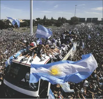  ?? Buenos Aires, Argentina,tuesday. RODRIGO ABD/AP ?? THE ARGENTINE SOCCER TEAM ride on top of an open bus during their homecoming parade in