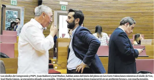  ?? Manuel Bruque / EFE ?? Los síndics de Compromís y PSPV, Joan Baldoví y José Muñoz, hablan antes del inicio del pleno en Les Corts Valenciane­s mientras el síndic de Vox, José María Llanos, se encuentra situado a su espalda. El debate sobre las nuevas leyes transcurri­ó en un ambiente bronco, con mucha tensión.