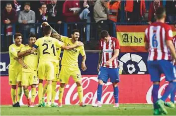  ?? AFP ?? Villarreal’s players celebrate after Roberto Soriano scored a last-gasp goal during the La Liga match against Atletico Madrid at the Vicente Calderon stadium in Madrid on Tuesday.