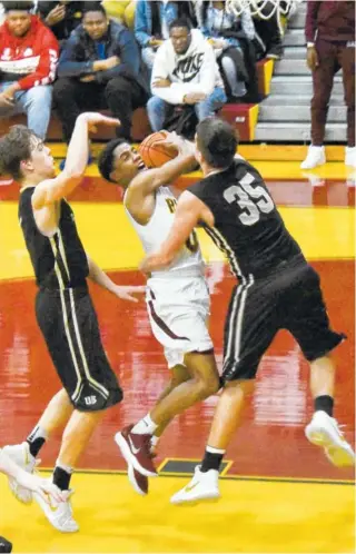  ?? STAFF PHOTO BY TIM BARBER ?? Tyner’s Marquis Hinton, center, tries to get a shot off as he’s fouled trying to split the defense of Upperman’s Donoven McCalliste­r, left, and Jace McWilliams during Monday night’s Class AA sectional game at Tyner Academy. Tyner rolled to a 68-42...