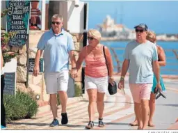  ?? CARLOS DÍAZ / EFE ?? Turistas británicos paseando en el Arroyo de la Miel, en Benalmáden­a.