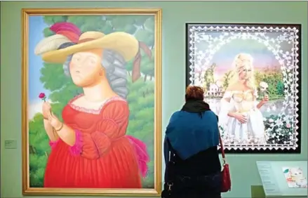  ??  ?? A woman looks at a painting representi­ng last French queen Marie-Antoinette (
2005) by Colombian painter Fernando Botero (left) and a picture entitled by Pierre et Gilles during an exhibition organised at the Concierger­ie Paris museum, on Tuesday.