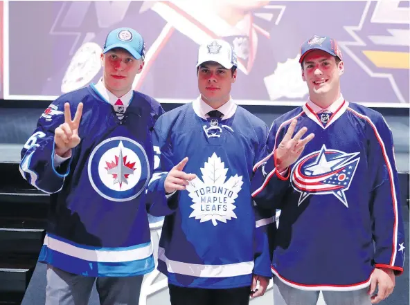  ?? — GETTY IMAGES FILES ?? Winnipeg Jets’ Patrik Laine, left, and Toronto Maple Leafs’ Auston Matthews, centre, were second and first picks in the 2016 NHL draft but Columbus Blue Jackets’ Pierre-Luc Dubois, who was third, says he could figure in the rookie race if he plays in...