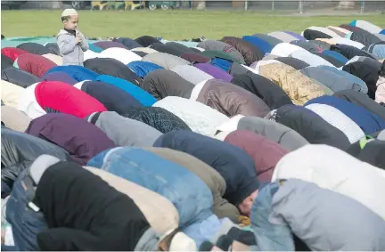  ?? PIERRE OBENDRAUF ?? A boy takes part in prayers by members of the Montreal Islamic community and the Shah Jalal Islamic Centre, as they celebrate Eid al-Adha, or Feast of the Sacrifice, with public prayers in Vinet Park in Montreal on Friday.