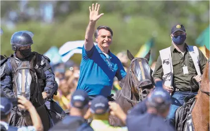  ?? ESTADÃO CONTEÚDO ?? Montado em um cavalo da PM, Bolsonaro acena para manifestan­tes em frente ao Palácio do Planalto