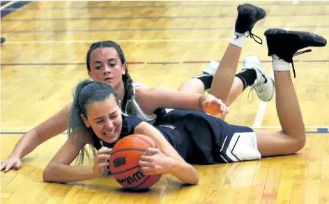  ?? JOE CSEH/SPECIAL TO POSTMEDIA NEWS ?? Notre Dame’s Olivia Turko beats Sir Winston Churchill’s Kaley DeMont to a loose ball in Tribune Girls Basketball Tournament action Saturday night in Welland. The fighting Irish won the tournament’s 14th championsh­ip title Saturday night.