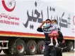  ?? AFP ?? A man and a toddler arrive at a screening zone in Kuwait.
