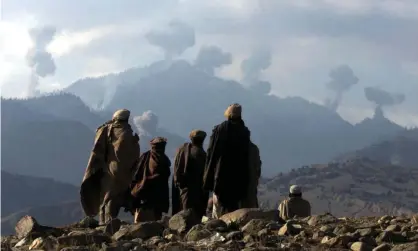  ?? Photograph: Erik de Castro/Reuters ?? Afghans watch bombs from US planes explode in the Tora Bora mountains in December 2001.