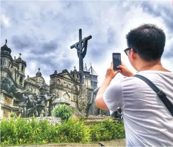  ?? SUNSTAR FILE ?? LANDMARK. A tourist takes a photo of the Heritage of Cebu Monumental Sculptural Tableau in Barangay Parian, Cebu City.