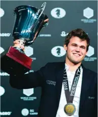  ?? (AFP) ?? In this December 1, 2016, picture, Magnus Carlsen of Norway holds up his trophy after defeating Russia’s Sergey Karjakin at the World Chess Championsh­ip in New York.