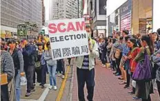  ?? AP ?? A pro-democracy protester displays a placard during a demonstrat­ion in Hong Kong yesterday, as protesters demand genuine universal suffrage.