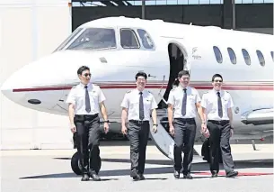  ?? ?? Employees disembark a private jet operated by Siam Land Flying Co.