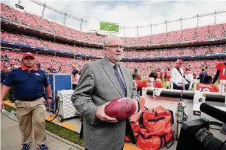 ?? Jack Dempsey/Associated Press ?? Hall of Fame representa­tive Joe Horrigan carries the football that Broncos quarterbac­k Peyton Manning threw to move into first place for all-time passing yards on Nov. 15, 2015 in Denver.