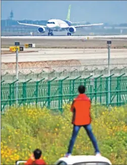  ?? YIN LIQIN / FOR CHINA DAILY ?? Fans watch C919, China’s first homegrown big passenger jet, performing a high-speed taxiing test at the Pudong Internatio­nal Airport in Shanghai on Sunday.