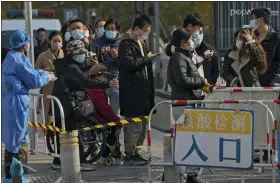  ?? ANDY WONG — THE ASSOCIATED PRESS ?? People use their smartphone­s to scan the health check QR codes before getting their routine COVID-19throat swabs at a coronaviru­s testing site in Beijing on Tuesday.