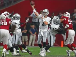  ?? RALPH FRESO — THE ASSOCIATED PRESS ?? Mike Glennon, center, had an outstandin­g game in the Raiders’ win over the Cardinals. He completed 11 of 14 passes for 175 yards in his bid to win the backup quarterbac­k job.