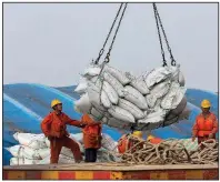  ?? AP ?? Workers unload soybeans last month at a port in Nantong in China’s eastern Jiangsu province. China proposed $50 billion worth of tariffs on U.S. soybeans, cars, chemicals and other goods on Wednesday in response to tariffs proposed by the United States.