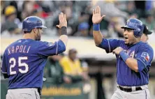  ?? Ben Margot / Associated Press ?? Yorvit Torrealba (right) makes happy-hands with Mike Napoli after both scored for the Rangers in the third inning.