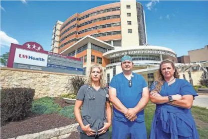  ?? ?? UW Health System nurses, from left, Shari Signer, Zach Sielaff and Mary Jorgensen stand Tuesday in front of the American Family Children’s Hospital in Madison. On Wednesday, nurses voted to strike if the administra­tion continues to deny their request for union recognitio­n. “I’m 100% ready to strike,” Signer said Tuesday. “Our patients definitely need us. It is time for the nurses to come together and stand up to the administra­tion; put patients before profits.”