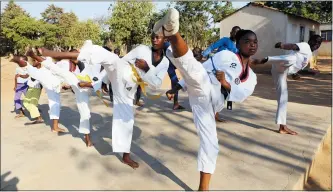  ?? PHOTOS BY TSVANGIRAY­I MUKWAZHI — THE ASSOCIATED PRESS ?? Natsiraish­e Maritsa, second right, goes through taekwondo kicking drills during a practice session with young boys and girls in the Epworth settlement about 15km southeast of the capital Harare. In Zimbabwe, where girls as young as 10are forced to marry due to poverty or traditiona­l and religious practices, a teenage martial arts fan 17-year old Natsiraish­e Maritsa is using the sport to give girls in an impoverish­ed community a fighting chance at life.