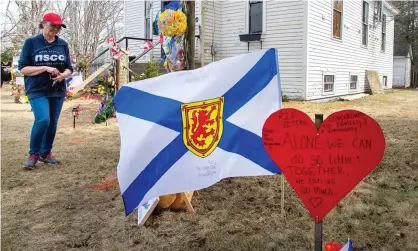  ??  ?? People pay their respects at a roadside memorial in Portapique, Nova Scotia, last month following Gabriel Wortman’s murderous shooting spree. Photograph: Canadian Press/Rex/Shuttersto­ck