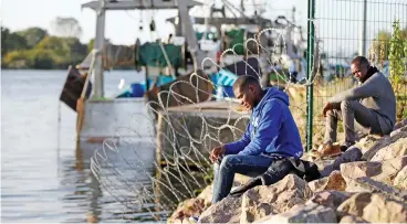  ?? (AFP) ?? Migrants wait on the side of a road near the Brittany ferry port in Ouistreham, northweste­rn France, on Tuesday