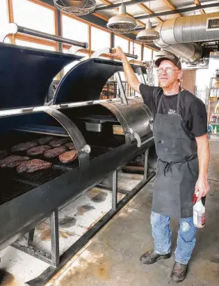  ?? J.C. Reid / Contributo­r ?? Pitmaster Bill Dumas uses four 1,000-gallon Moberg smokers at The Switch in Austin.