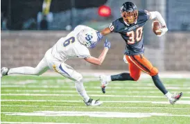  ??  ?? Tulsa Washington’s Dax Hill stiff-arms Stillwater’s Jack Smithton while returning a punt during Friday’s game. [PHOTOS BY IAN MAULE, TULSA WORLD]