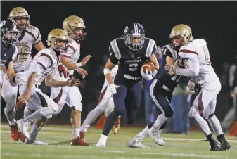  ?? Scott Strazzante / The Chronicle ?? Facing 4th-and-8, Marin Catholic’s Ben Skinner evades the Cardinal Newman defense on a long gain to set up the go-ahead touchdown to win the North Coast Section Division 3 title game.