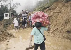  ??  ?? 0 Filipino families flee deadly mudslides caused by the typhoon