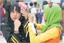  ??  ?? Muslim women prepare for a cosplay event at a mall in Petaling Jaya, Malaysia.