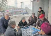  ?? FILE/GETTY IMAGES ?? Elderly people play a game next to the railway tracks in Hebei, just outside Beijing.