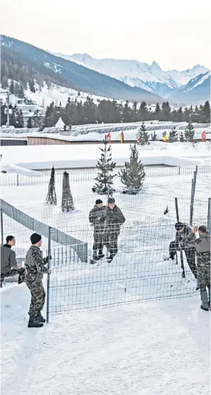  ??  ?? Swiss Army soldiers set up fences around the Congress Center, the venue of the 50th World Economic Forum